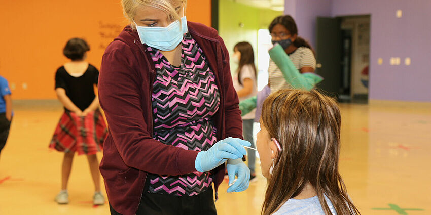 woman testing a child for covid