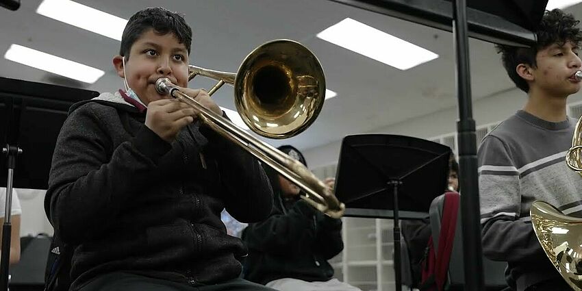 middle school boy playing a trombone