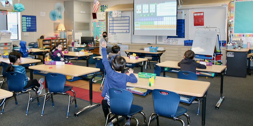 boy raising hand in classroom