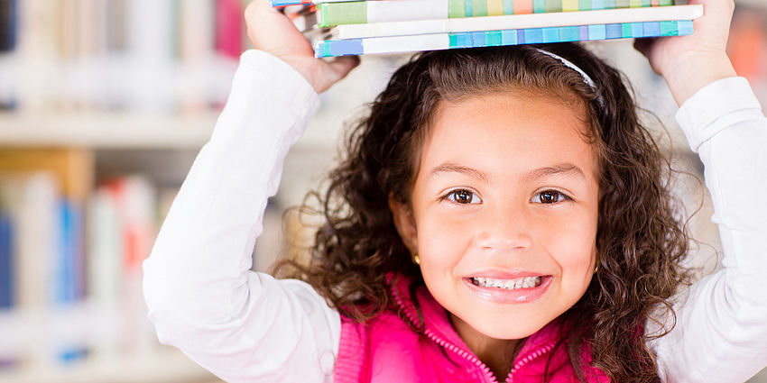 girl smiling holding books