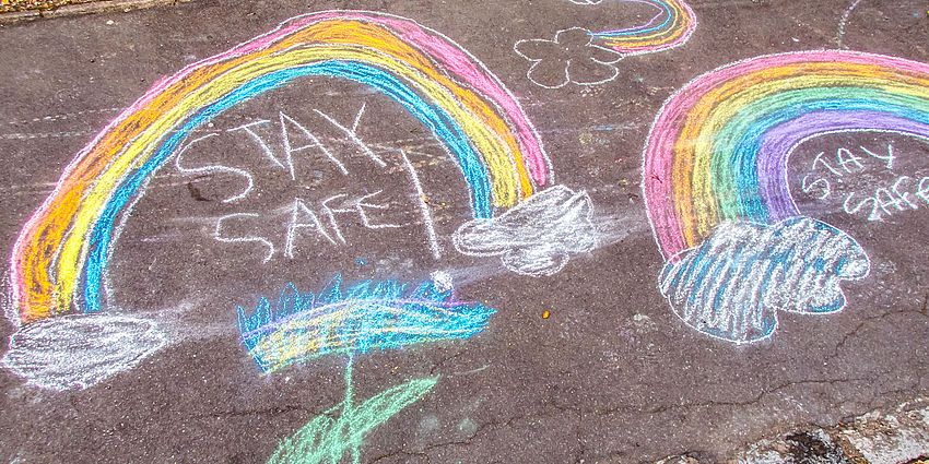 stay safe and chalk rainbows drawn on sidewalk