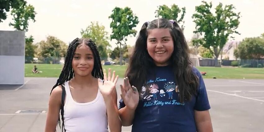 two middle school girls waving hello