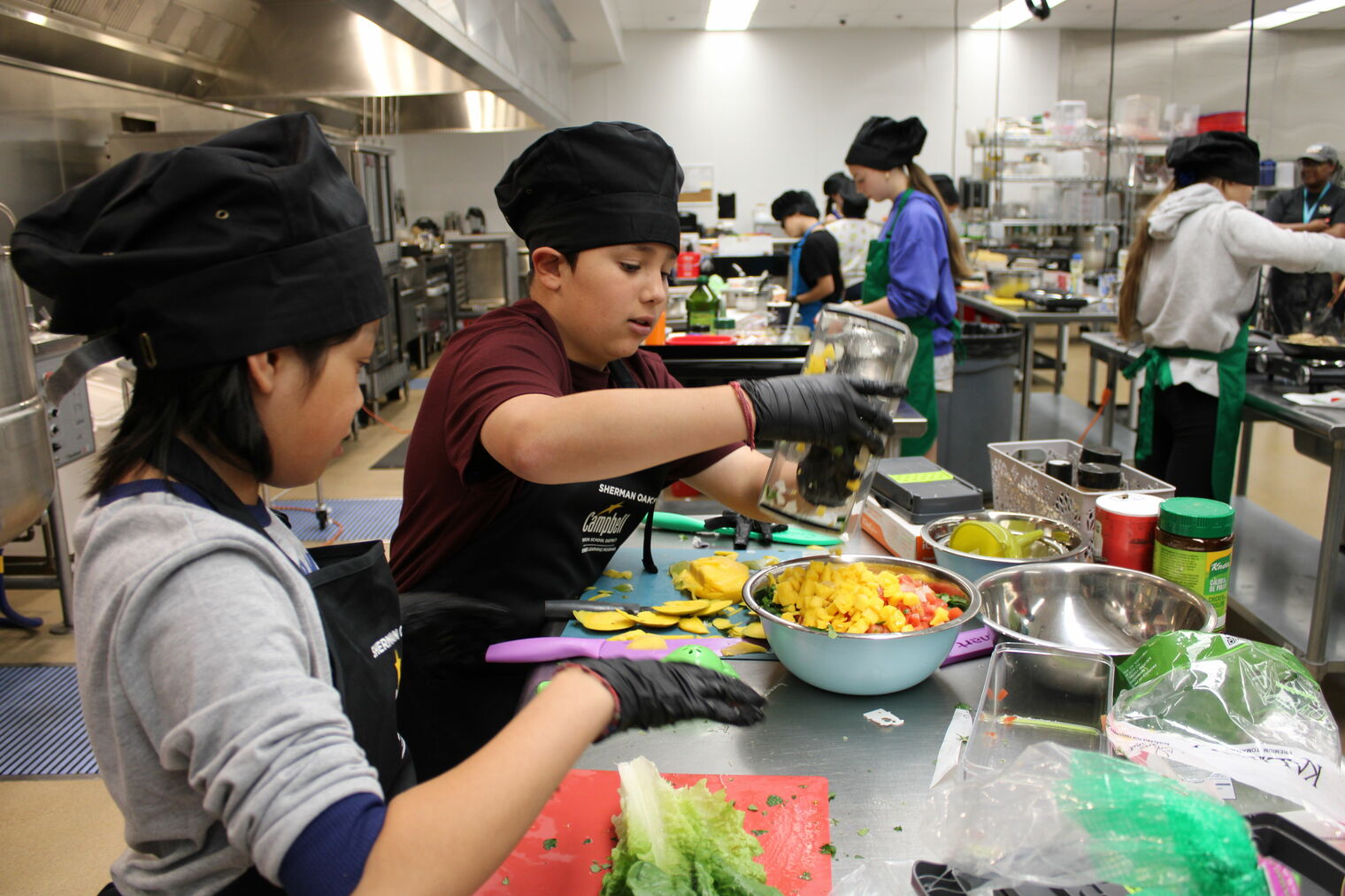 Students preparing their dishes for the 2025 cooking competition.
