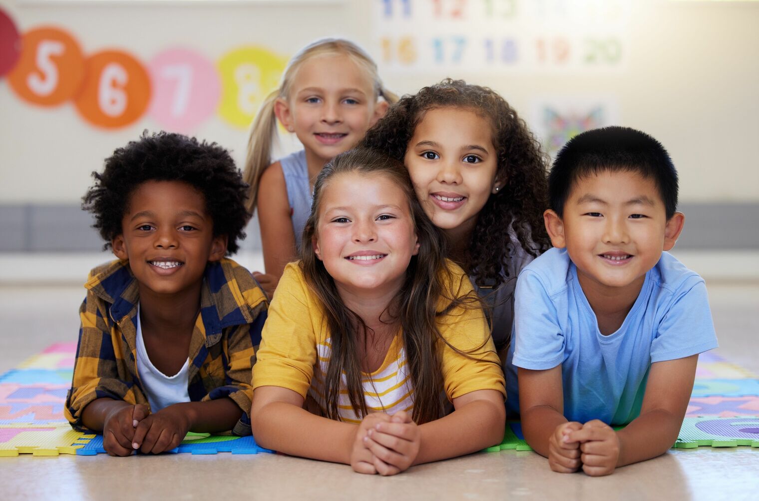 A happy group of 5 primary grade students of diverse ethnicities 